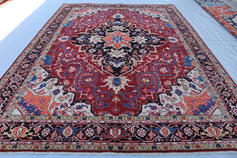 May include: A large, intricately patterned rug with a red background and a central medallion. The rug features a variety of colors, including blue, white, and orange, and has a detailed border.