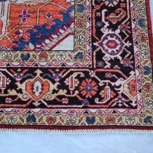 May include: A traditional Persian rug with a dark red, black, and cream color scheme. The rug features intricate floral and geometric patterns.