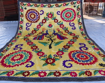 May include: A yellow silk tapestry with intricate embroidery featuring two peacocks, a tree, and floral designs in shades of red, blue, green, and purple.