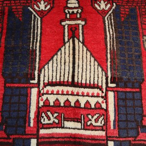 May include: A red prayer rug with a white and brown mosque design in the center. The rug has a blue border with white floral patterns.