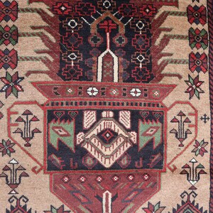 Pu&ograve; includere: Un tappeto beige con un designo persiano tradizionale. Il tappeto presenta un medaglione centrale con intricati motivi floreali e geometrici in tonalit&agrave; di rosso, verde e nero.