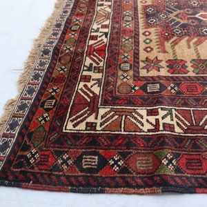 Pu&ograve; includere: Un tappeto tradizionale con sfondo beige e intricati motivi geometrici in tonalit&agrave; di rosso, marrone, verde e nero. Il tappeto ha un bordo con frange.