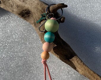 Wood bed keychain with colourful beads.