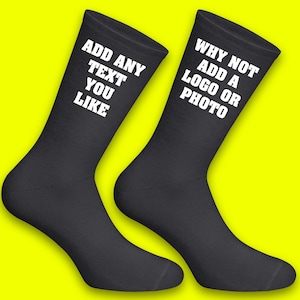 May include: Pair of black socks with white text. One sock says "Add any text you like" and the other says "Why not add a logo or photo".