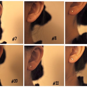 Pu&ograve; includere: Primo piano di sei piercing all'orecchio diversi, ognuno con un piccolo orecchino a perno semplice. Gli orecchini sono tutti dorati e vengono indossati nel lobo dell'orecchio. Gli orecchini sono numerati da 7 a 12.