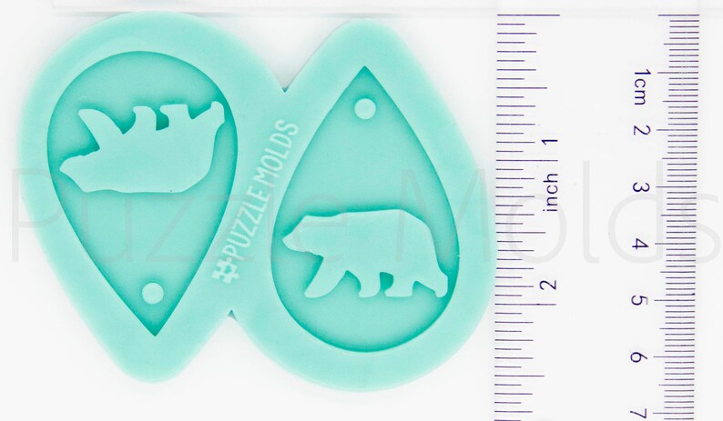 May include: Two teal blue silicone molds for making earrings. Each mold features a bear silhouette. The mold on the left has a mother bear with a cub. The mold on the right has a single bear walking. The molds are approximately 2 inches in length. #PuzzleMolds