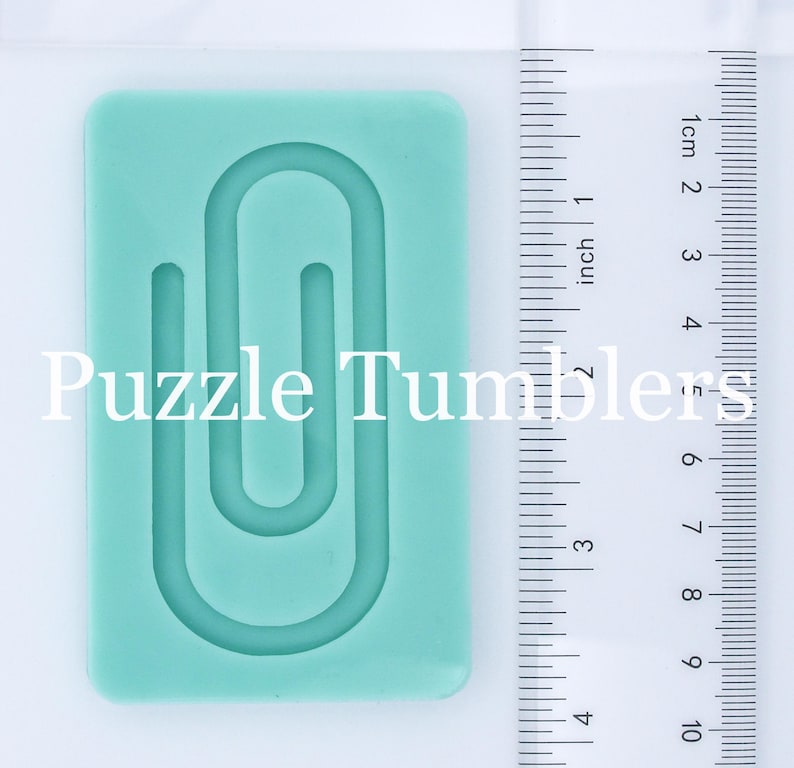May include: A light blue silicone mold shaped like a paperclip. The mold is approximately 2 inches tall and 1 inch wide. The mold is designed for making resin crafts.