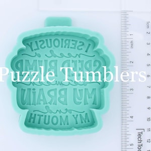 May include: A green silicone mold for resin crafts. The mold is shaped like a coffee cup with the text "My Brain is Fried I Seriously Need a Bump" written on it.