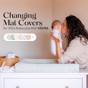 Könnte beinhalten: Wickelauflagen für IKEA Babycare Mat VÄDRA. Das Bild zeigt eine Wickelauflage mit hellblauem Bezug und einem Muster aus gelben Formen. Eine Auswahl an Bezugsdesigns wird über der Matte angezeigt. Eine Person hält ein Baby.