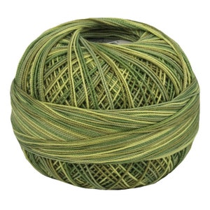 Op de afbeelding: Een bolletje gemêleerd garen in groen- en geeltinten. Het garen is strak opgerold, met zichtbare strengen die een textuur creëren. Ideaal voor breien, haken of andere textielkunstprojecten.