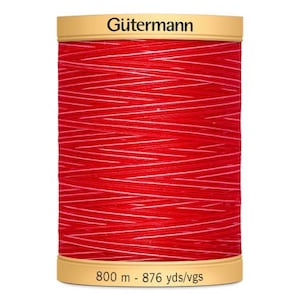 May include: A spool of red Gütermann thread with white stripes. The spool is labelled "Gütermann" and "800 m - 876 yds/vgs".