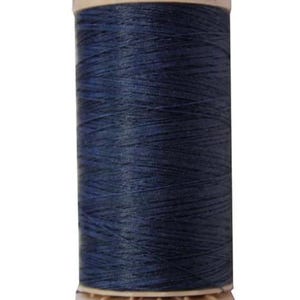 May include: A spool of navy blue thread with the brand name "Gütermann" printed on the top. The spool is cylindrical with a beige base and top. The text "0% Cotton / Coton" is printed on the base.