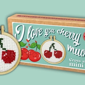 May include: A cross-stitch mini kit featuring a cherry design. The kit includes a wooden embroidery hoop with a completed cherry cross-stitch, and a box with the text "I love you cherry much!" and "Cross stitch mini kit".