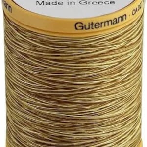 May include: A spool of Gutermann thread in colour 9938, a light brown shade. The spool is labelled "Col. 9938" and "Made in Greece". The spool is 50 metres long.