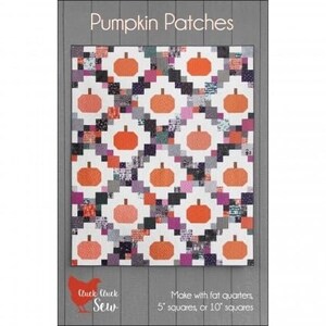 Peut inclure: Un modèle de courtepointe pour une courtepointe avec un motif de patchwork de citrouilles orange sur un fond blanc avec des accents noirs, gris et roses. Le modèle s'appelle "Pumpkin Patches" et est réalisé par Cluck Cluck Sew. Le modèle peut être réalisé avec des quartiers de tissu, des carrés de 5 pouces ou des carrés de 10 pouces.
