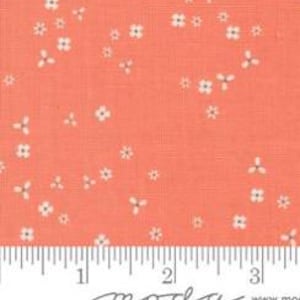 Könnte beinhalten: Korallenfarbener Stoff mit einem kleinen weißen Blumenmuster. Der Stoff wird mit einem Lineal in Zoll gemessen. Der Stoff hat eine gewebte Textur und eignet sich für Quilt- oder Nähprojekte.