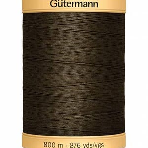 May include: A dark brown Gütermann thread spool. The spool has a beige label at the top with the brand name and a beige label at the bottom with the measurement of 800 m - 876 yds/vgs.