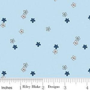 Könnte beinhalten: Hellblauer Stoff mit einem verstreuten Blumenmuster. Das Design zeigt kleine weiße und marineblaue Blumen. Das Bild enthält ein Lineal, das Zoll anzeigt.