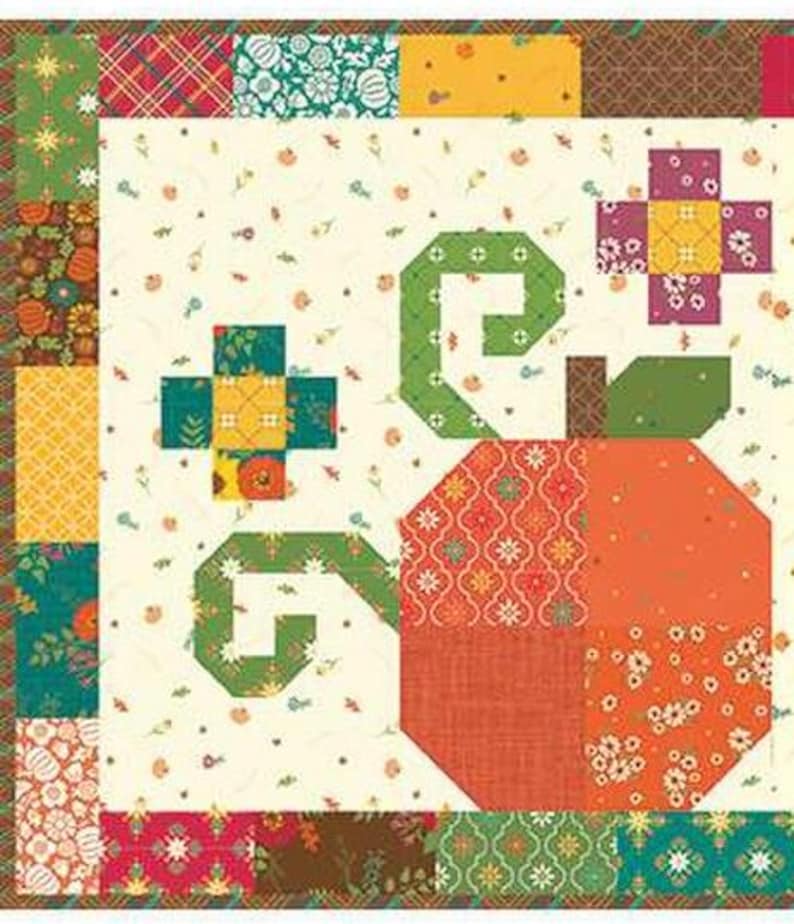 May include: A patchwork quilt block with a large, stylised pumpkin in shades of orange and red. The pumpkin has a green stem and vine. The background is cream-coloured with small floral patterns, and the border is a mix of patterned fabrics.
