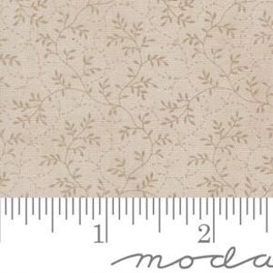 May include: Tan fabric with a repeating pattern of delicate, light brown vines and leaves. The fabric is measured with a ruler in inches, showing a scale of 2 inches. The word "moda" is printed at the bottom.