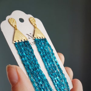 Pendientes de botón "Cometa" en oro y azul turquesa, con flecos de cuentas hechos a mano en estilo "Interstellar", elaborados por Cornish Maid, libres de plástico, estilo festivalero, listos para regalar.