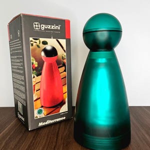 Peut inclure: Une tasse en céramique blanche avec une anse noire et le texte "But First, Coffee" en noir, dans une police manuscrite. La tasse est posée sur une surface blanche.