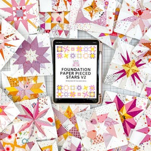 May include: A collection of colorful, star-shaped fabric quilt blocks in various sizes and designs. The blocks are predominantly pink, white, yellow, and purple. A tablet displays the text "FOUNDATION PAPER PIECED STARS V2".
