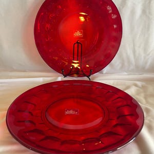 Puede incluir: Una taza de cerámica blanca con un asa negra y el texto "But First, Coffee" en negro, con una fuente de estilo manuscrito. La taza está sobre una superficie blanca.