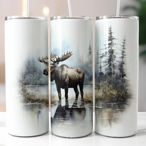 Op de afbeelding: Drie roestvrijstalen bekers met verschillende natuurthema's. De eerste beker heeft een aquarel-illustratie van een eland die in een meer staat. De tweede beker heeft een aquarel-illustratie van een eland die in een meer staat met bomen op de achtergrond. De derde beker heeft een aquarel-illustratie van bomen en een meer.