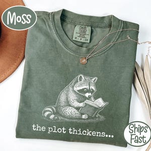 Comfort Colors® the plot thickens Bookish Raccoon Reading T-Shirt, Fantasy Book Lover Gift, Mystery Thriller Reader Shirt, Funny Trash Panda