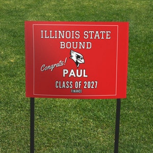 May include: Red and white yard sign with the text "Illinois State Bound" and a red bird logo. The sign also says "Congrats! Paul Class of 2027 Finance".