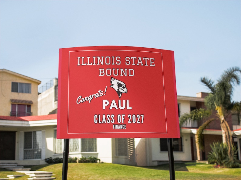 May include: Red and white yard sign with the text "Illinois State Bound" and a red bird logo. The sign also says "Congrats! Paul Class of 2027 Finance".