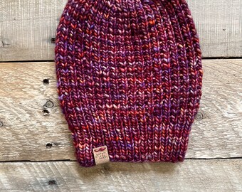 May include: A red, purple, and orange knitted beanie with a brown leather tag that says "Made with Love".