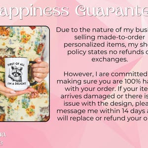 May include: White ceramic mug with a black handle. The mug has a black and white illustration of a raccoon with a knife and the text "First of all I'm a delight". The mug is being held by a person's hand. The background is a pink and white floral pattern.