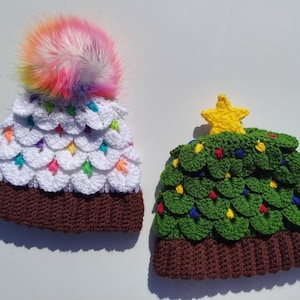 May include: Two crocheted hats, one white with a rainbow pom-pom and the other green with a yellow star on top. Both hats have brown brims.