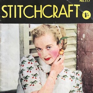 Könnte beinhalten: Ein Vintage-Magazincover mit einer Frau, die einen weißen Strickpullover mit Kirschmuster trägt. Das Magazin heißt "Stitchcraft" und die Cover-Nummer ist "No. 117".