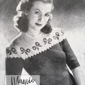 May include: Black and white photograph of a woman wearing a knitted jumper with a bow pattern. The jumper has a high neckline and short sleeves. The text "Miss Vincent - Vintage Pattern Reproduction" and "Mamie" are visible in the image.