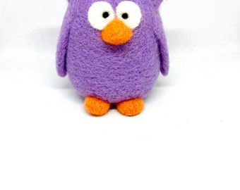 May include: A needle-felted owl figurine with a round purple body, two large white circular eyes with black pupils, a small orange beak, and two small orange feet. The texture of the owl appears fuzzy and soft throughout the surface.