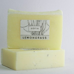 May include: Two rectangular bars of lemongrass soap, one stacked on top of the other. The soap is pale yellow with a white label that reads "SOFIA LEMONGRASS" with a botanical illustration.