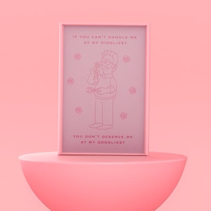 May include: A pink framed print with a cartoon illustration of a man with a mustache and glasses holding a flower and gardening shears. The text on the print reads "If you can't handle me at my diddliest, you don't deserve me at my doodliest."