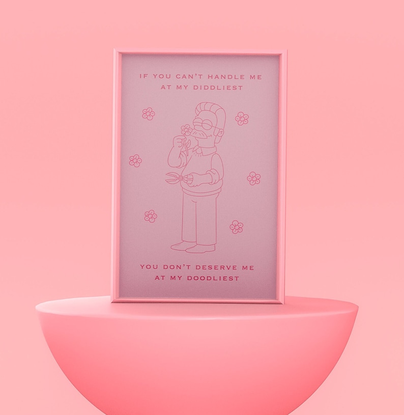 May include: A pink framed print with a cartoon illustration of a man with a mustache and glasses holding a flower and gardening shears. The text on the print reads "If you can't handle me at my diddliest, you don't deserve me at my doodliest."