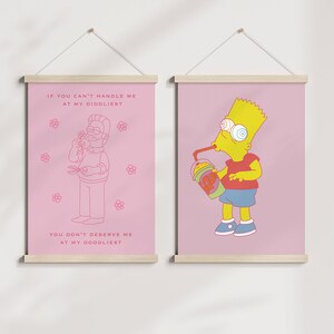 May include: Two pink framed prints with white text and cartoon illustrations. The left print features a cartoon man with a beard and the text "If you can't handle me at my diddliest, you don't deserve me at my doodliest". The right print features a cartoon yellow character with blue eyes and the text "If you can't handle me at my diddliest, you don't deserve me at my doodliest".