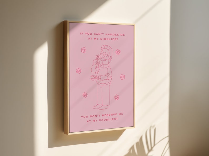 May include: A pink framed print with a cartoon illustration of a man holding a flower and a pair of scissors. The text reads "If you can't handle me at my diddliest, you don't deserve me at my doodliest."