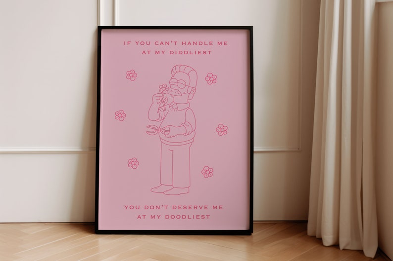 May include: A pink framed poster with a cartoon illustration of a man with a mustache and glasses holding a flower. The text on the poster reads "If you can't handle me at my diddliest, you don't deserve me at my doodliest."