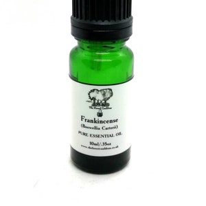 May include: A small green glass bottle with a black lid containing Frankincense (Boswellia Carterii) Pure Essential Oil. The bottle is labeled with the text "The Forest Cauldron" and the website address "www.theforestcauldron.co.uk". The bottle contains 10 ml or .35 oz of oil.