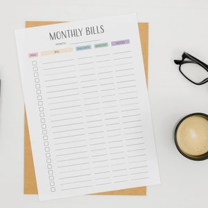 May include: A printable monthly bill tracker with columns for month, bill, due date, amount, and notes. The tracker is printed on white paper and has a brown envelope behind it. There is a black pen, a cup of coffee, and a pair of glasses on a white surface.
