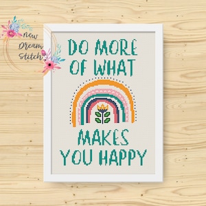 May include: Cross stitch pattern with a rainbow and a flower with a crown. The text reads "Do more of what makes you happy."