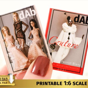 May include: Two miniature magazine covers with the title "Couture" and the logo "dAb" printed on them. The covers feature fashion models wearing elaborate outfits.