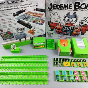 以下が含まれることがあります： 「Jedeme Bomby!」というボードゲーム。緑色のゲームコンポーネント、カード、漫画のキャラクターが描かれた箱があります。ゲームにはタイマーと66のミッションが含まれています。2〜5人でプレイでき、30分で終わります。