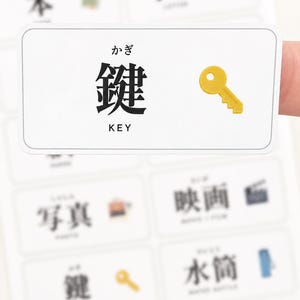 May include: A rectangular white sticker featuring the Japanese kanji for key, the hiragana reading kagi, and the English word KEY in black text, accompanied by a small yellow key icon. The sticker is part of a larger sheet of educational labels.